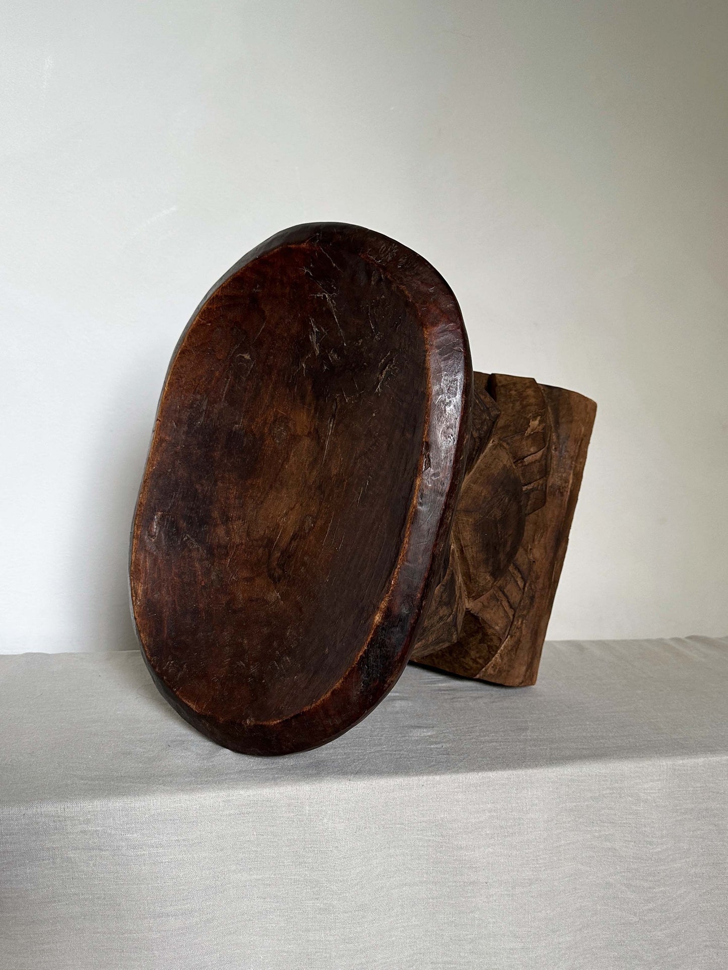 an antique tribal stool with concaved seat