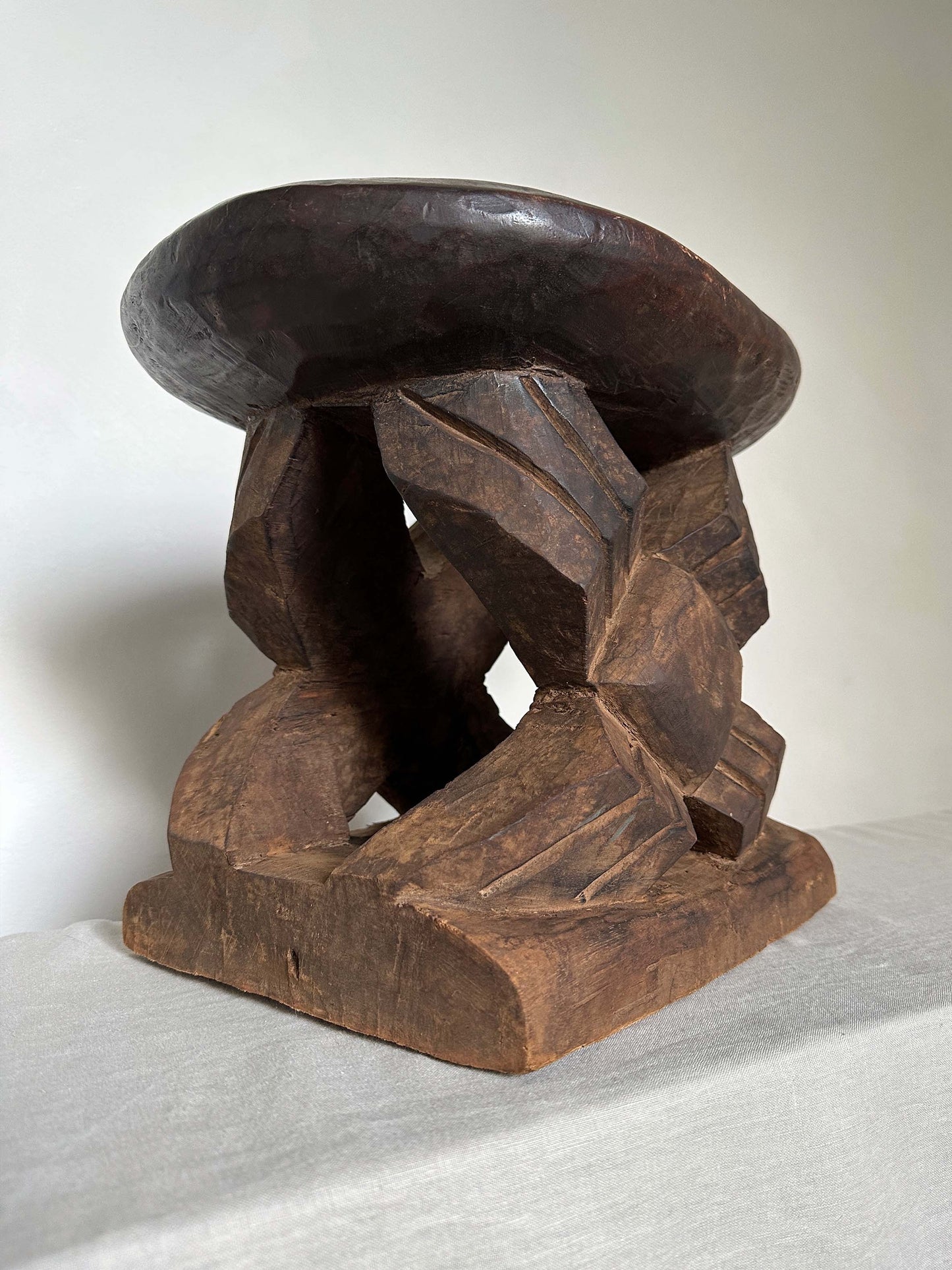 an antique tribal stool with concaved seat