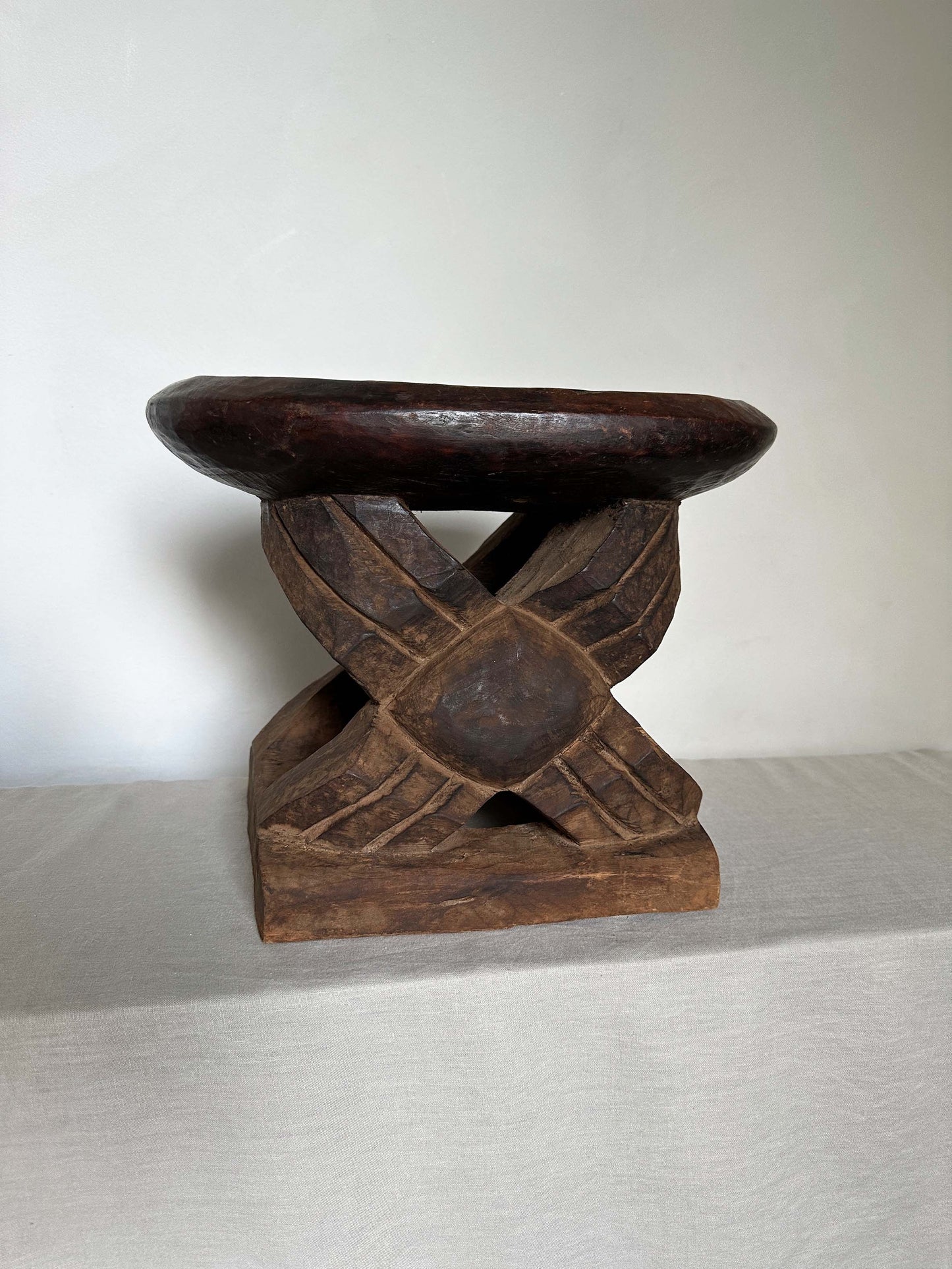 an antique tribal stool with concaved seat