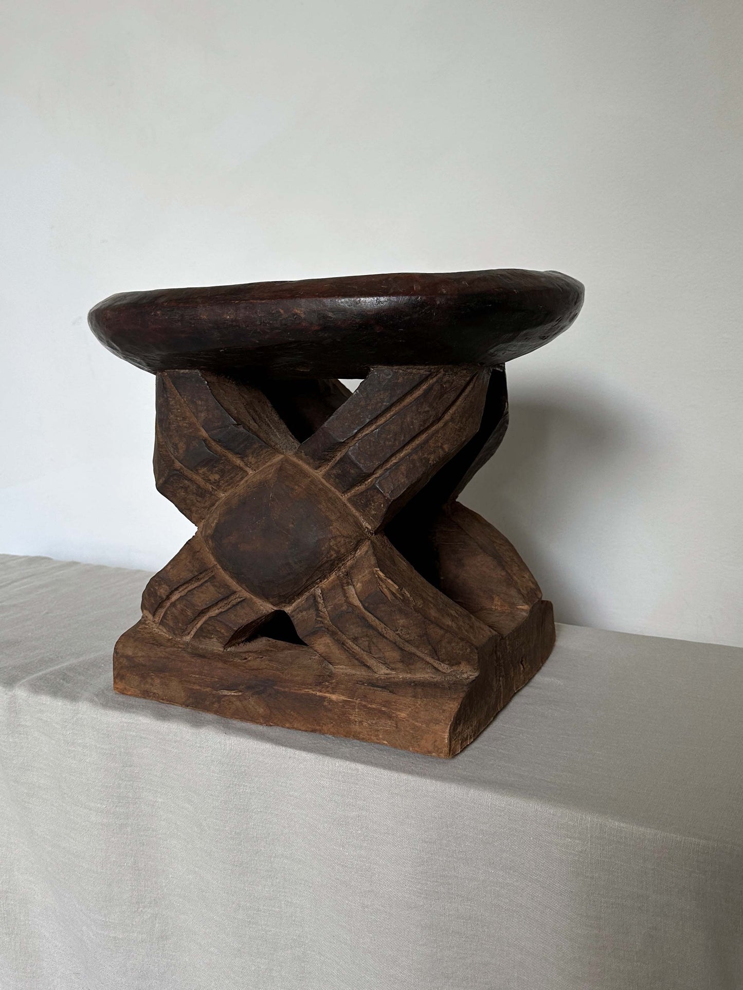 an antique tribal stool with concaved seat