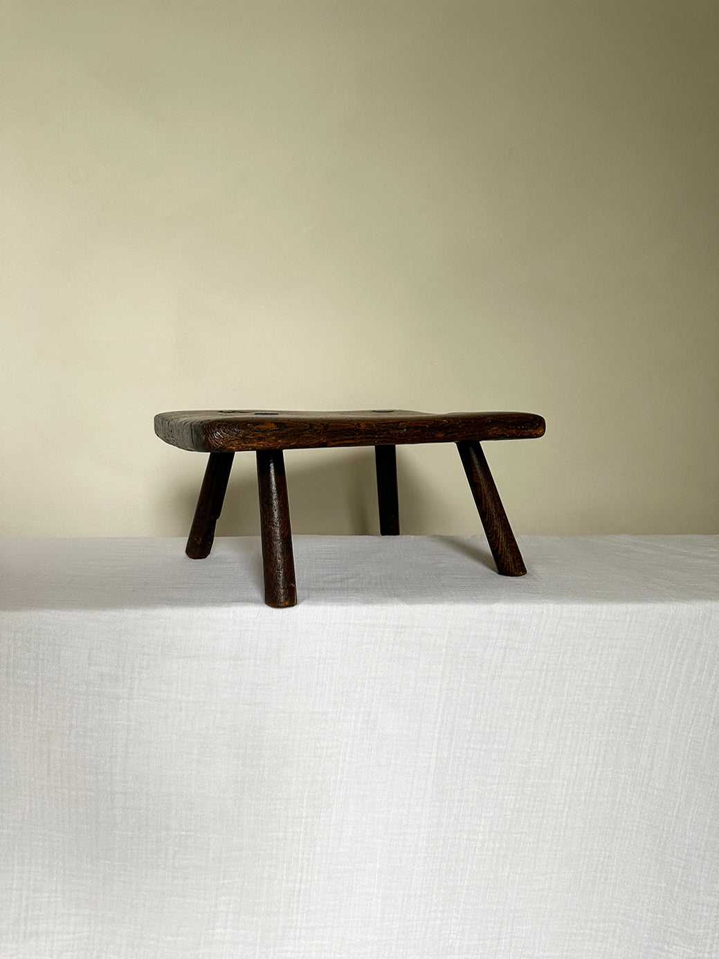 an antique wabi sabi table stool hand-carved from super sturdy dark wood