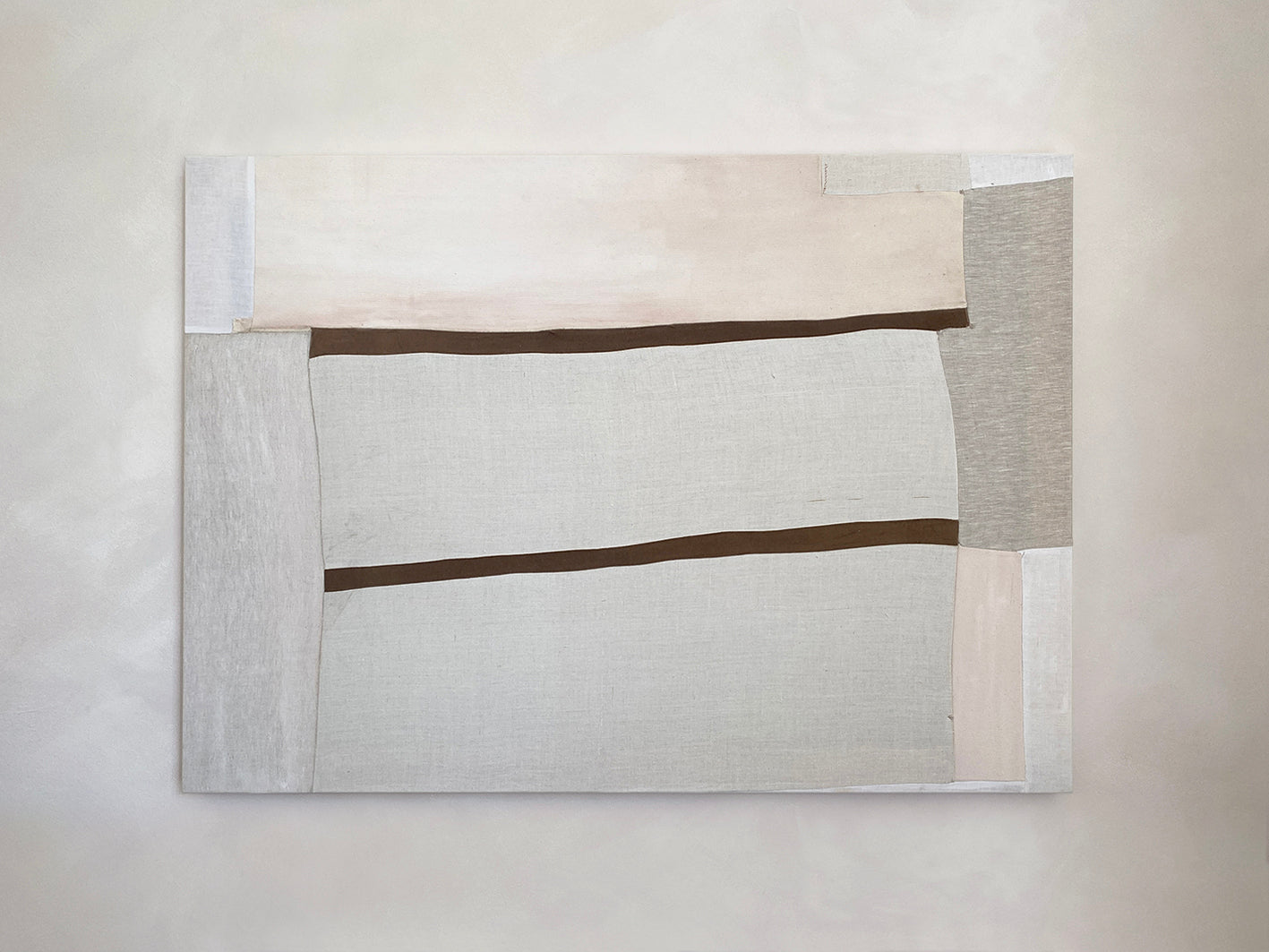 a large abstract artwork with neutral fabric painterly elements and two strips of brown velvet