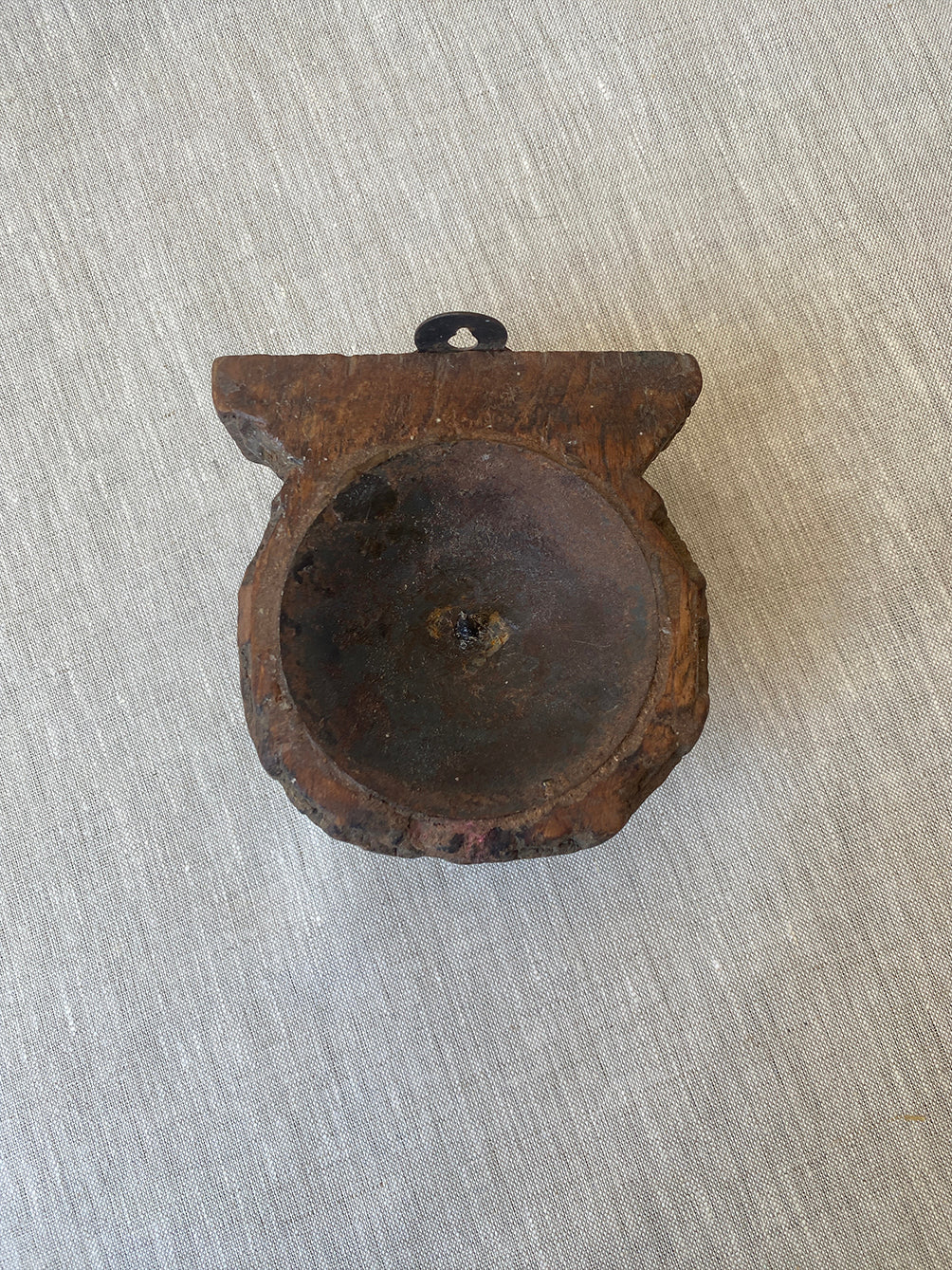 a rustic, hand-carved wooden candle sconce with delicate engraving