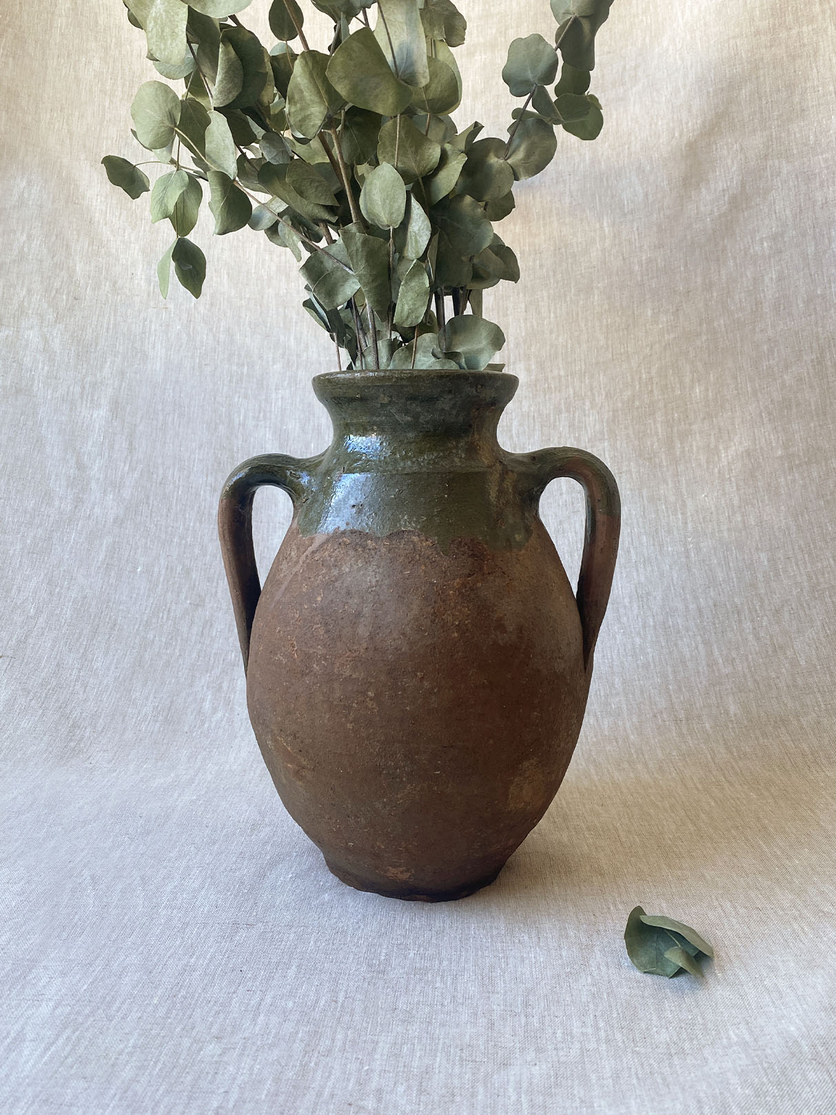 a rustic double-handle turkish drip vase traditionally used to store oil in the off season