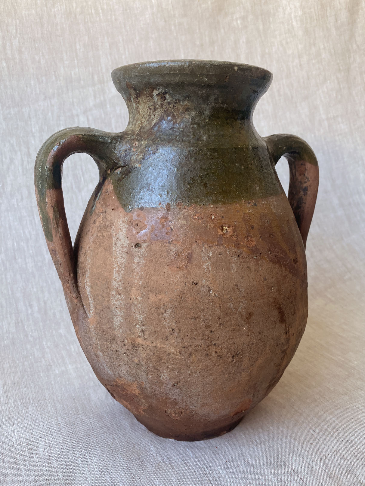 a rustic double-handle turkish drip vase traditionally used to store oil in the off season