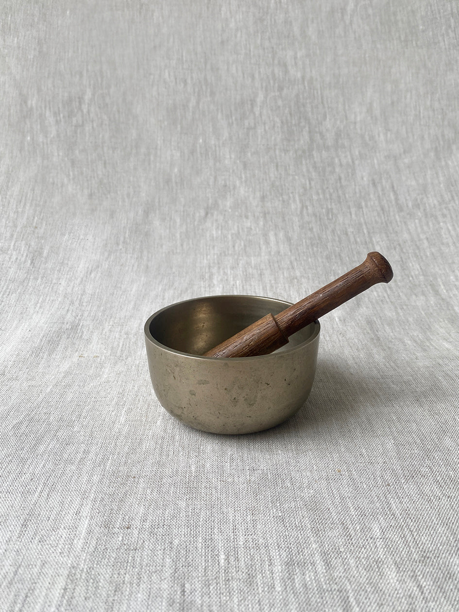 an antique meditation bowl with a small wooden striker