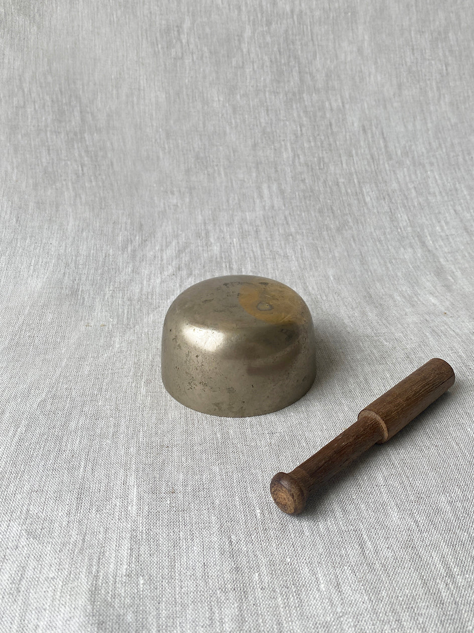 an antique meditation bowl with a small wooden striker