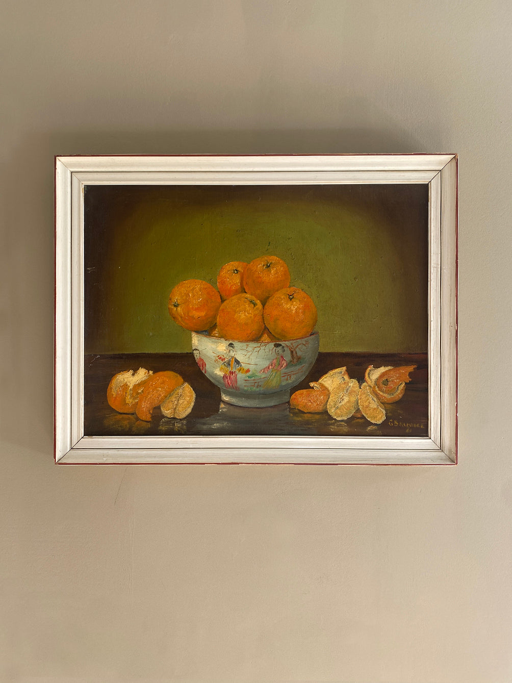 a vintage oil painting in a white wood frame