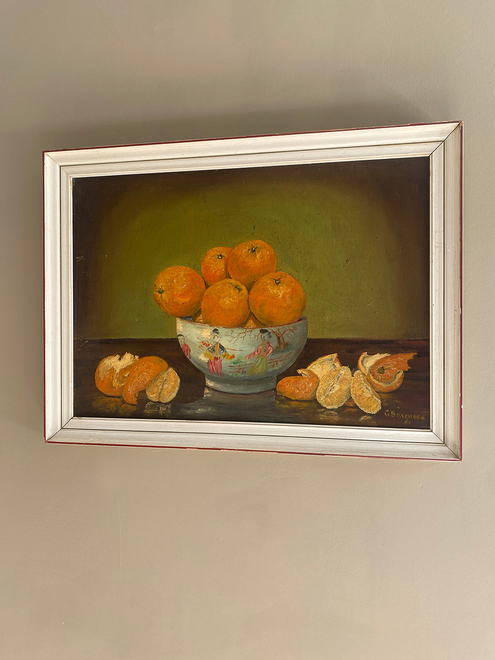 a vintage oil painting in a white wood frame