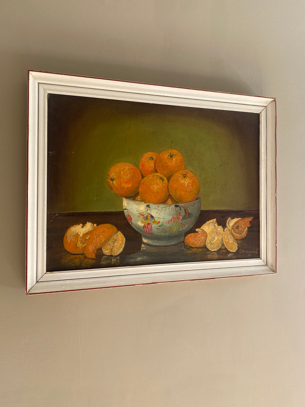 a vintage oil painting in a white wood frame