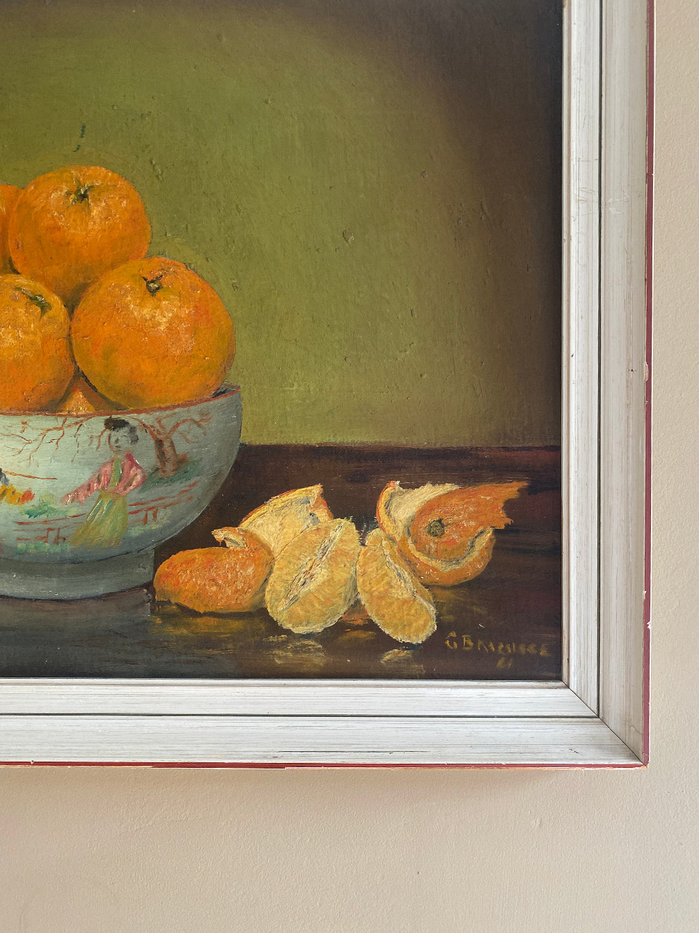 a vintage oil painting in a white wood frame