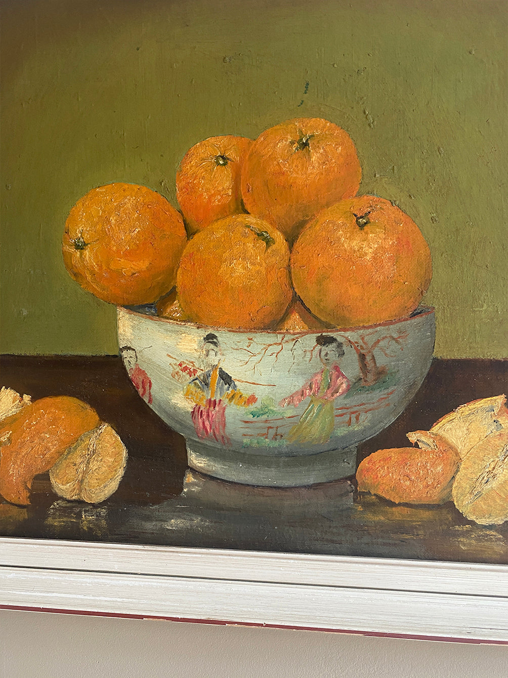a vintage oil painting in a white wood frame