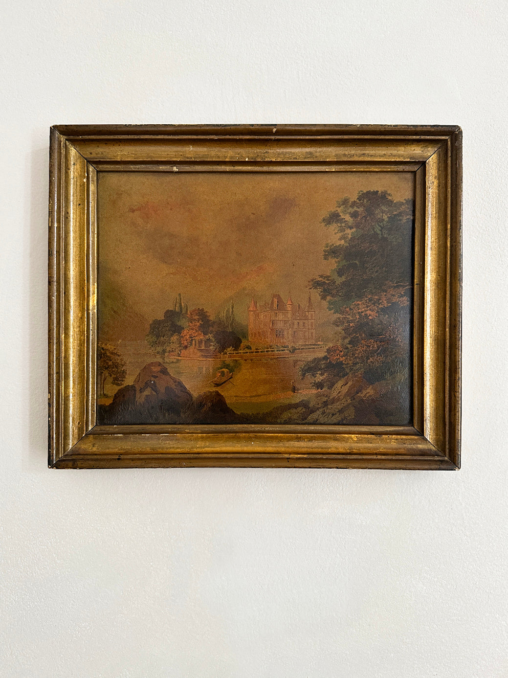 an antique oil painting in a gilt wood frame, of a french chateau and landscape 