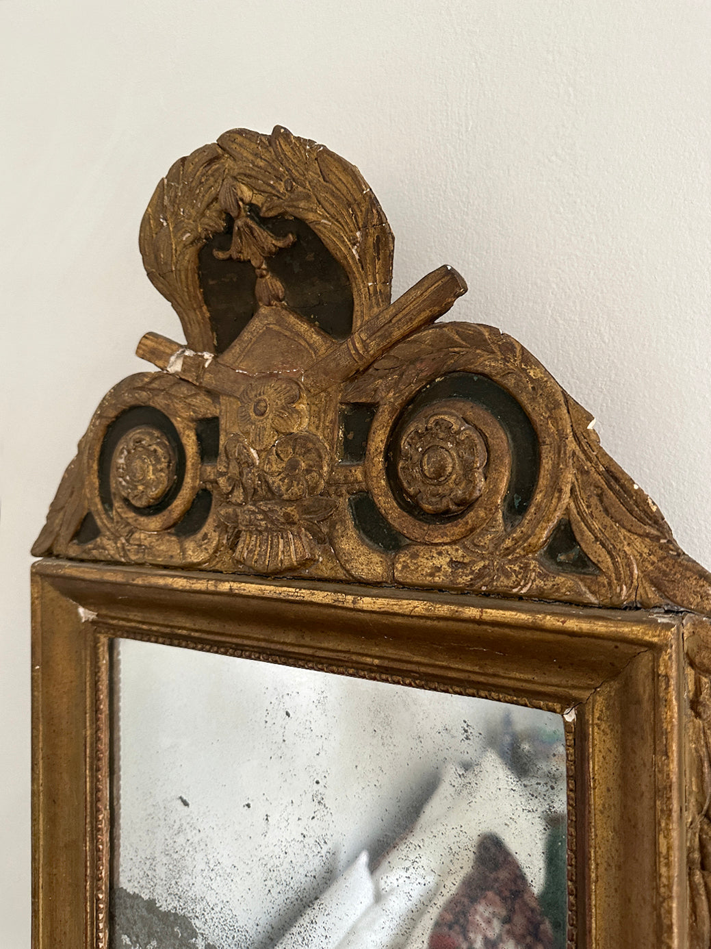 An antique French 18th-century Louis XVI-style mirror, decorated with tassels and laurel leaves in original gildwood.