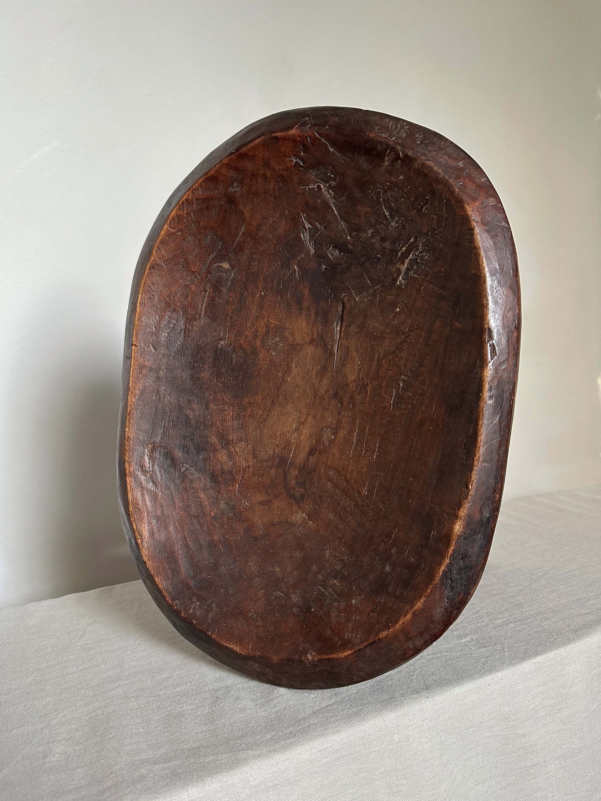 an antique tribal stool with concaved seat 