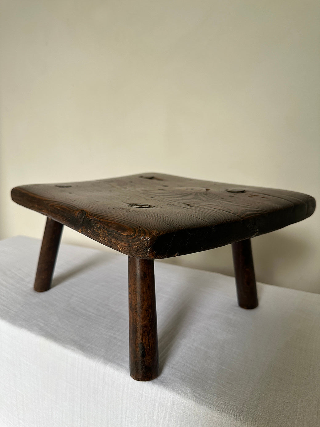 an antique wabi sabi table stool hand-carved from super sturdy dark wood