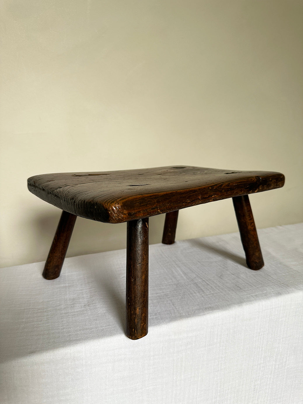 an antique wabi sabi table stool hand-carved from super sturdy dark wood