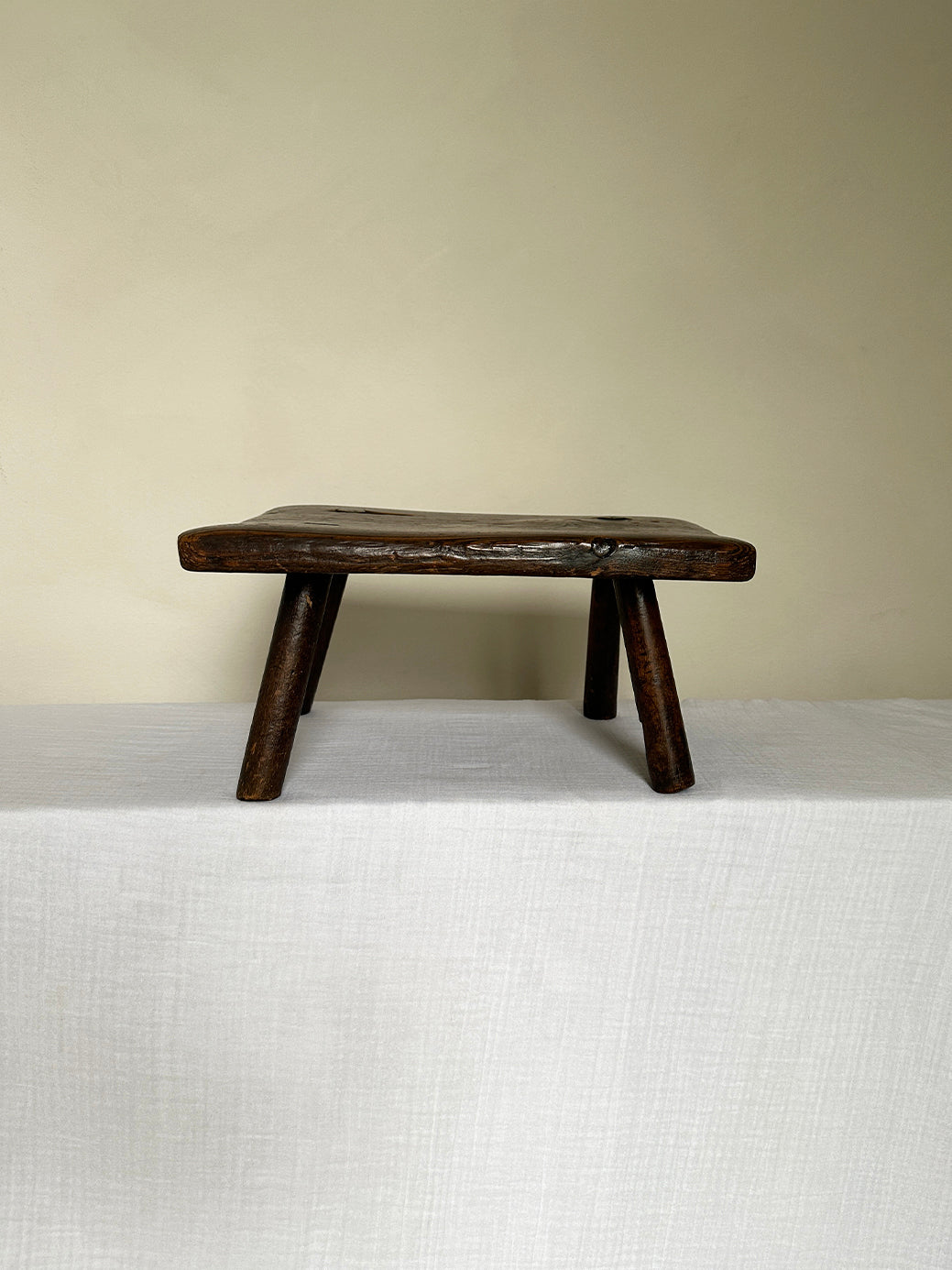 an antique wabi sabi table stool hand-carved from super sturdy dark wood