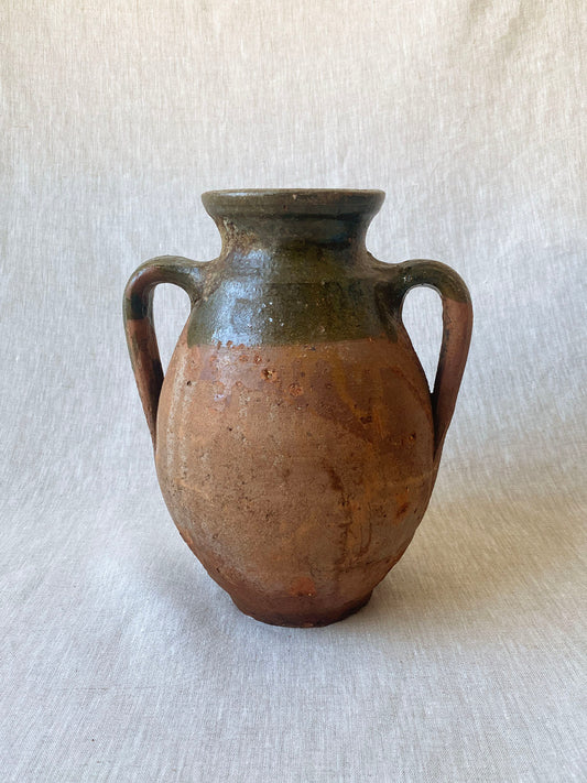 a rustic double-handle turkish drip vase traditionally used to store oil in the off season