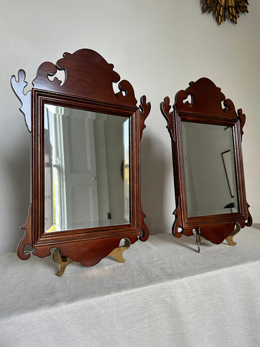 a pair of antique mahogany chippendale-style mirrors with bevelled glass