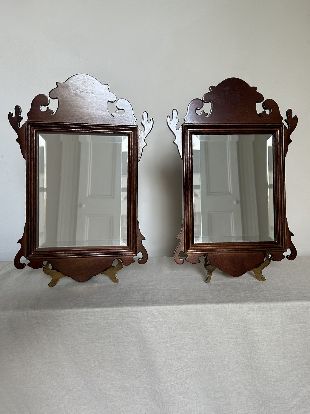 a pair of antique mahogany chippendale-style mirrors with bevelled glass