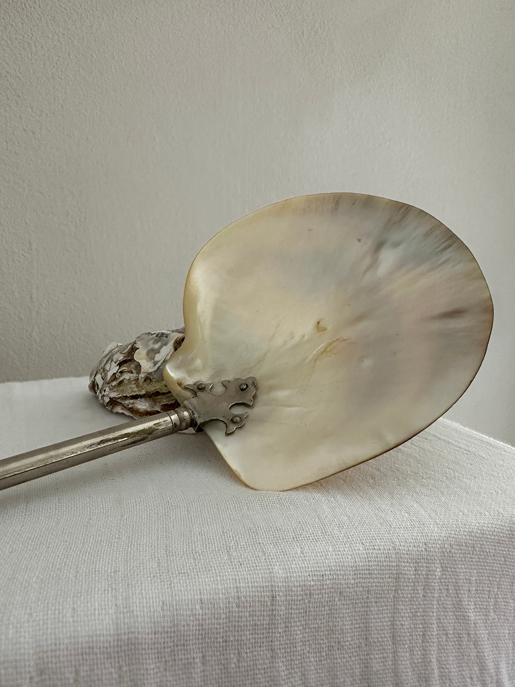 An antique mother-of-pearl caviar spoon with a gilt-brass handle and gothic mounting.