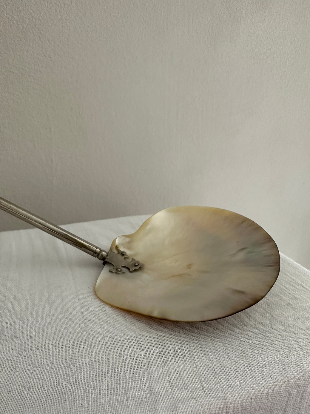 An antique mother-of-pearl caviar spoon with a gilt-brass handle and gothic mounting.