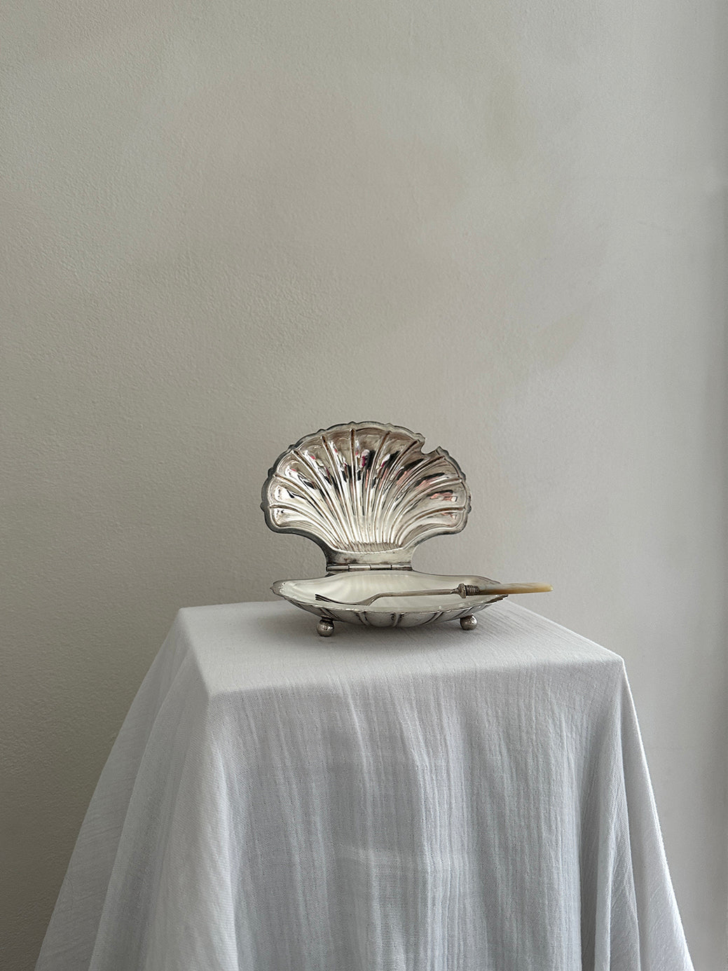 a victorian silver plated caviar dish in the shape of a clamshell, with silver feet and a glass insert