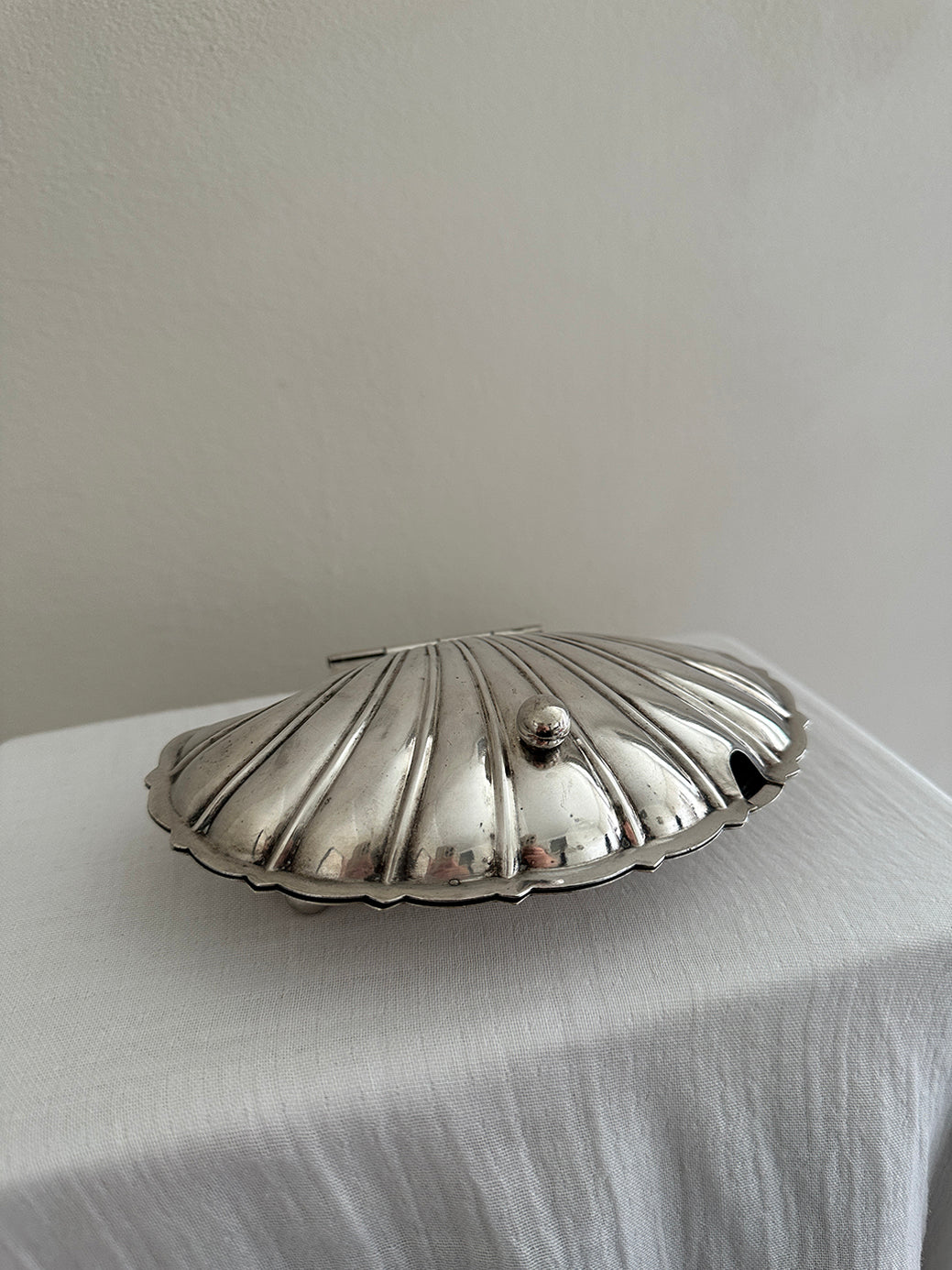 a victorian silver plated caviar dish in the shape of a clamshell, with silver feet and a glass insert