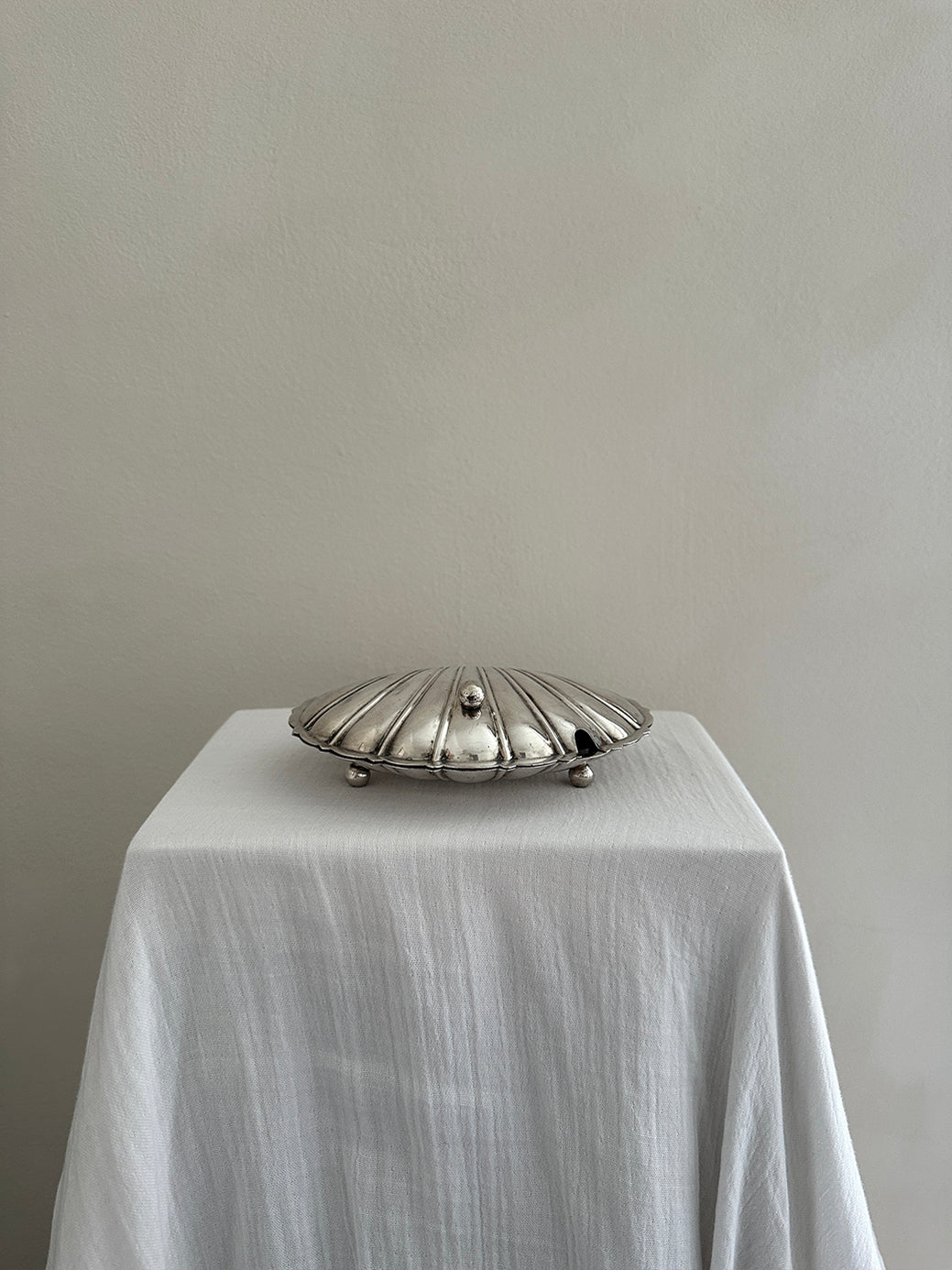 a victorian silver plated caviar dish in the shape of a clamshell, with silver feet and a glass insert