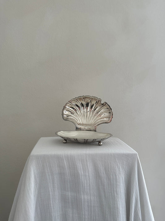 a victorian silver plated caviar dish in the shape of a clamshell, with silver feet and a glass insert