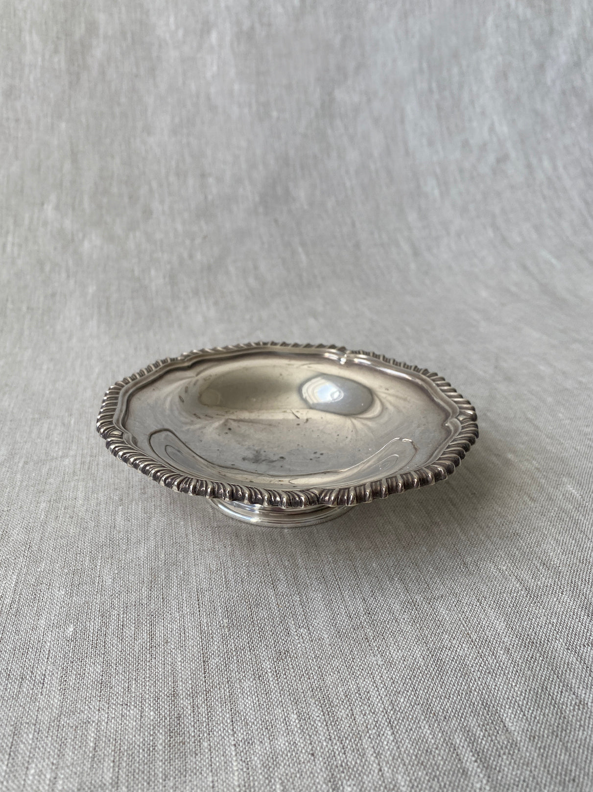 a small silver-plated trinket dish with elevated base