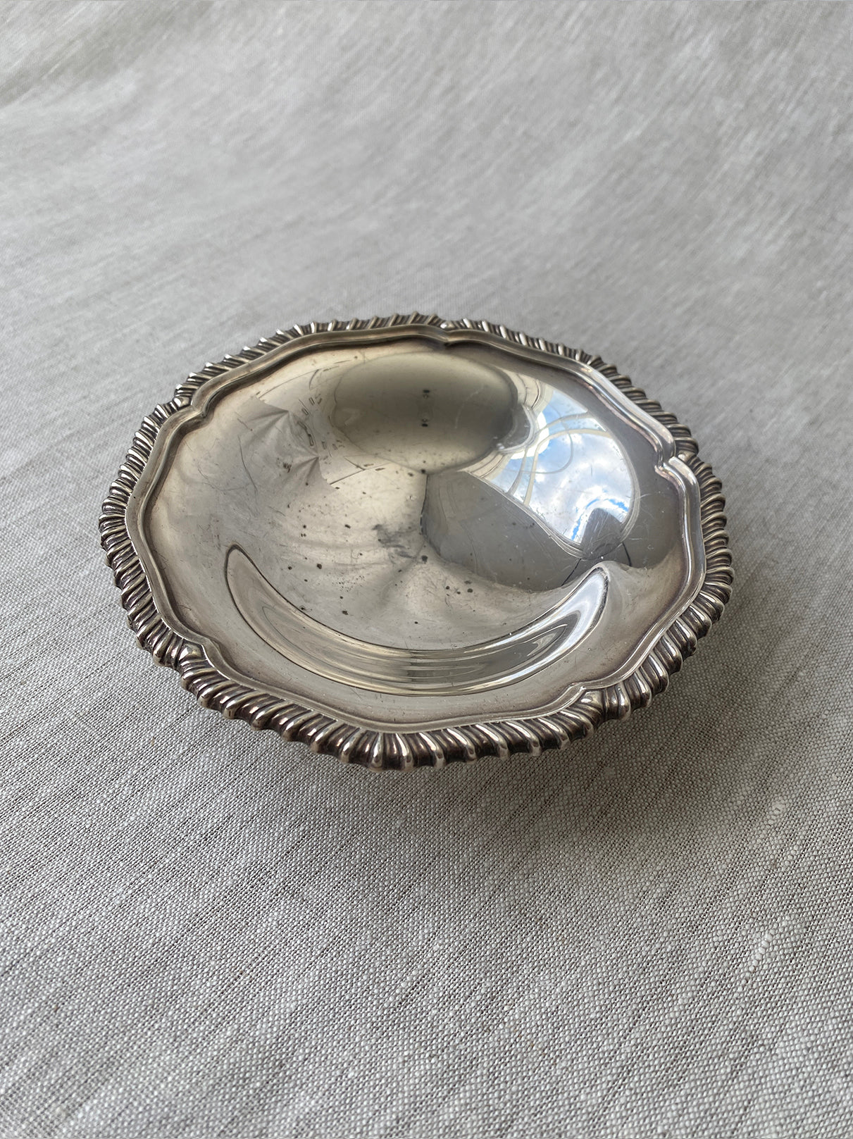 a small silver-plated trinket dish with elevated base