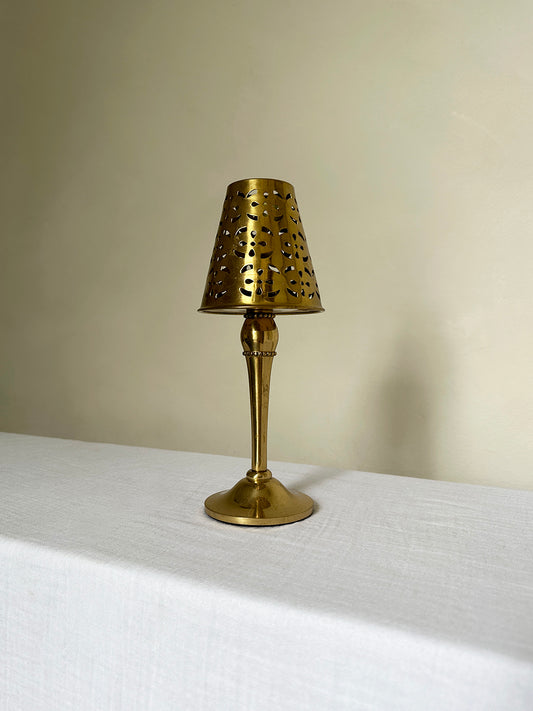 a solid brass tealight candle holder with a perforated shade