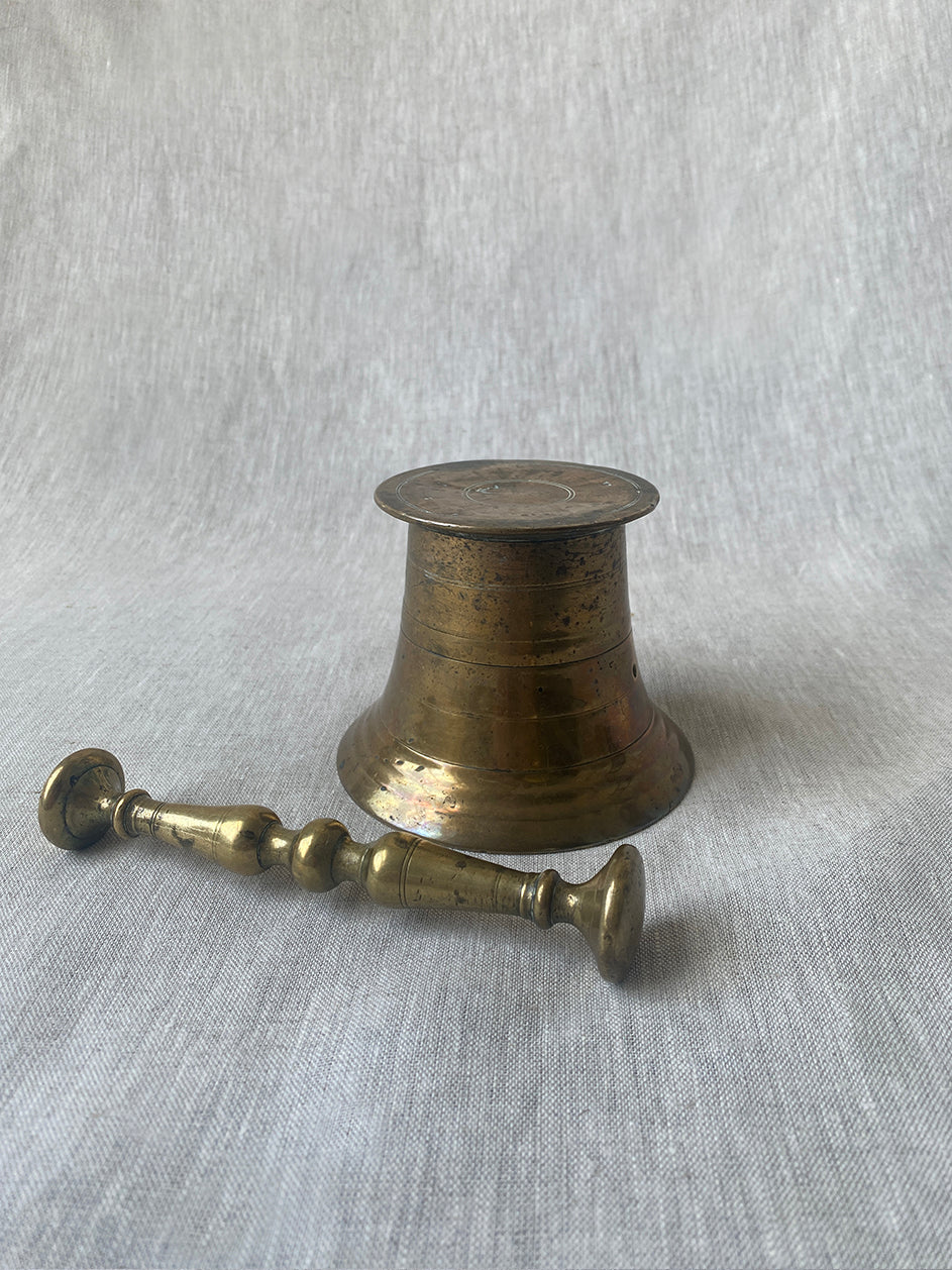 an antique medicial mortar and pestle in solid brass