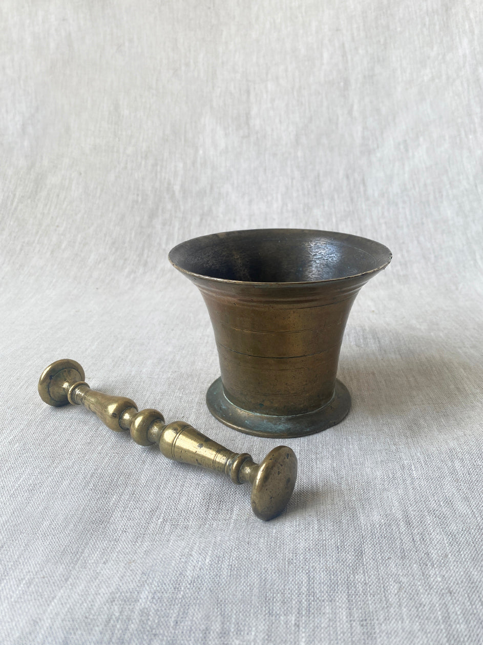 an antique medicial mortar and pestle in solid brass