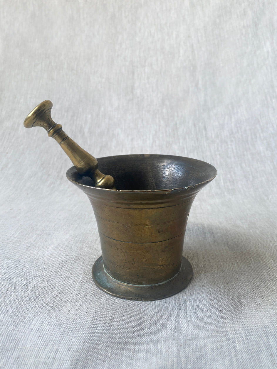 an antique medicial mortar and pestle in solid brass