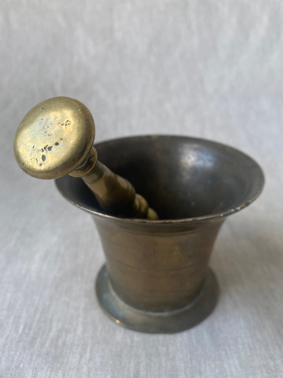 an antique medicial mortar and pestle in solid brass