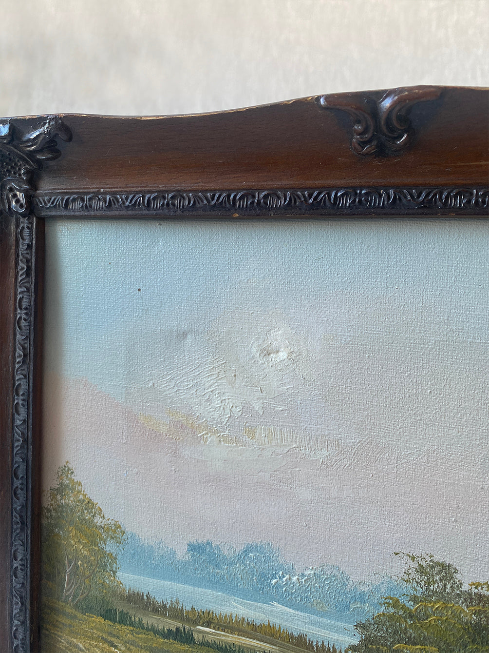 a vintage oil waterscape painting in an ornate wooden frame