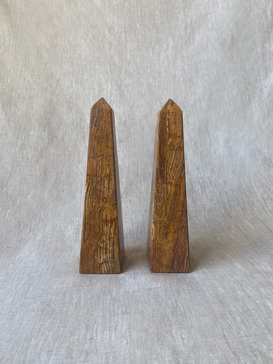 a pair of vintage marble obelisks in honey toned stone