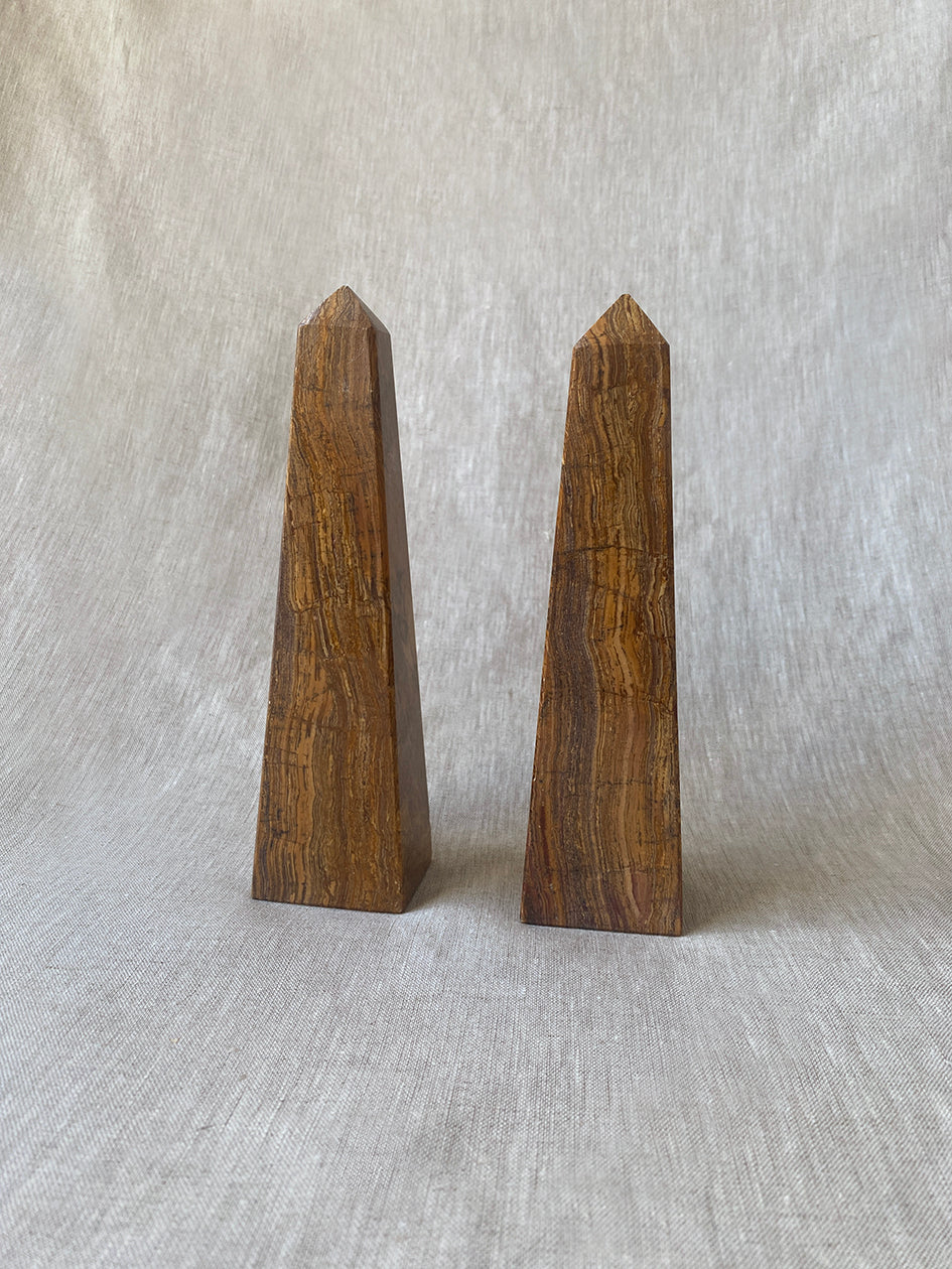 a pair of vintage marble obelisks in honey toned stone