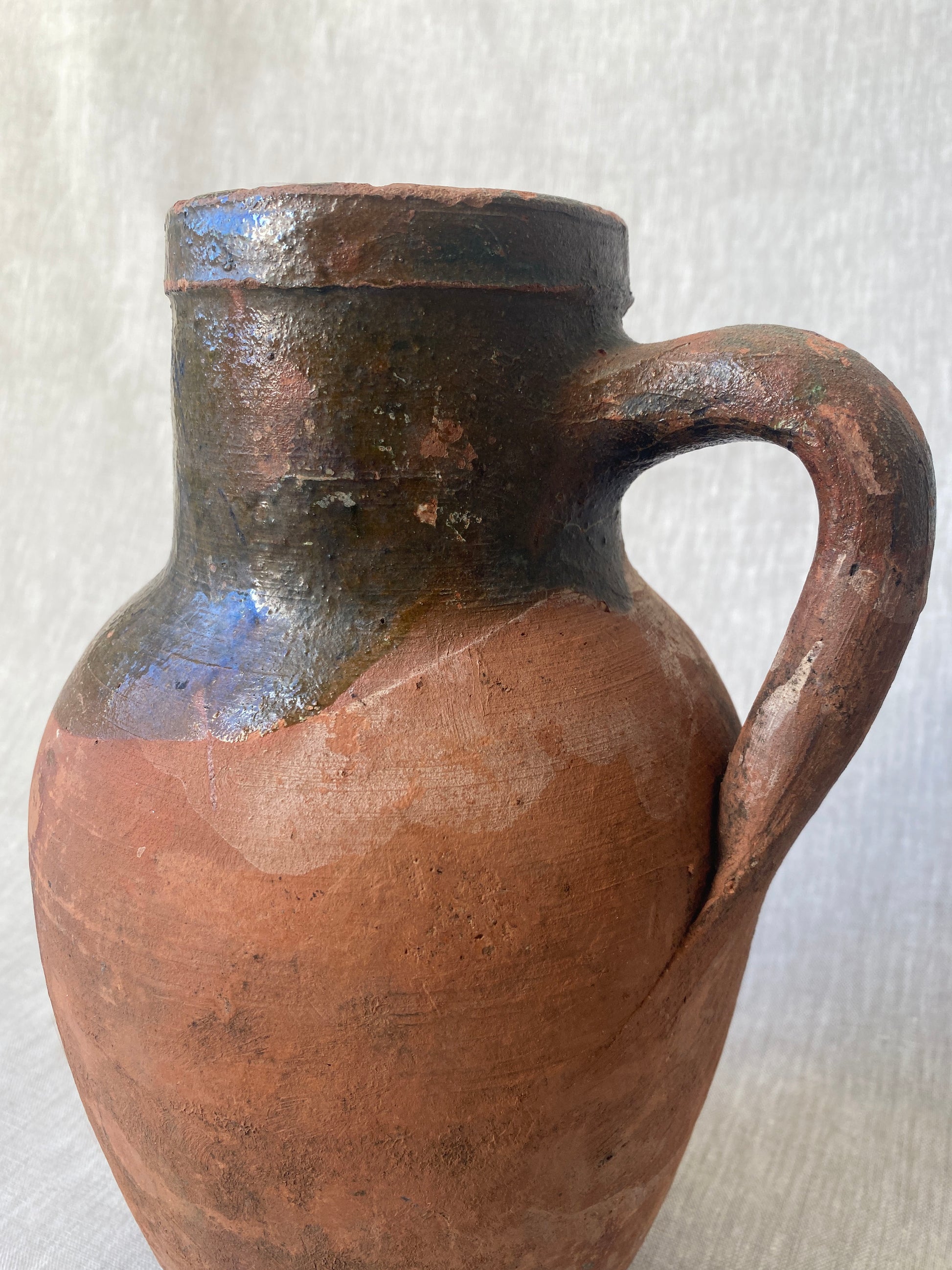 an antique turkish olive jar with a drip glaze