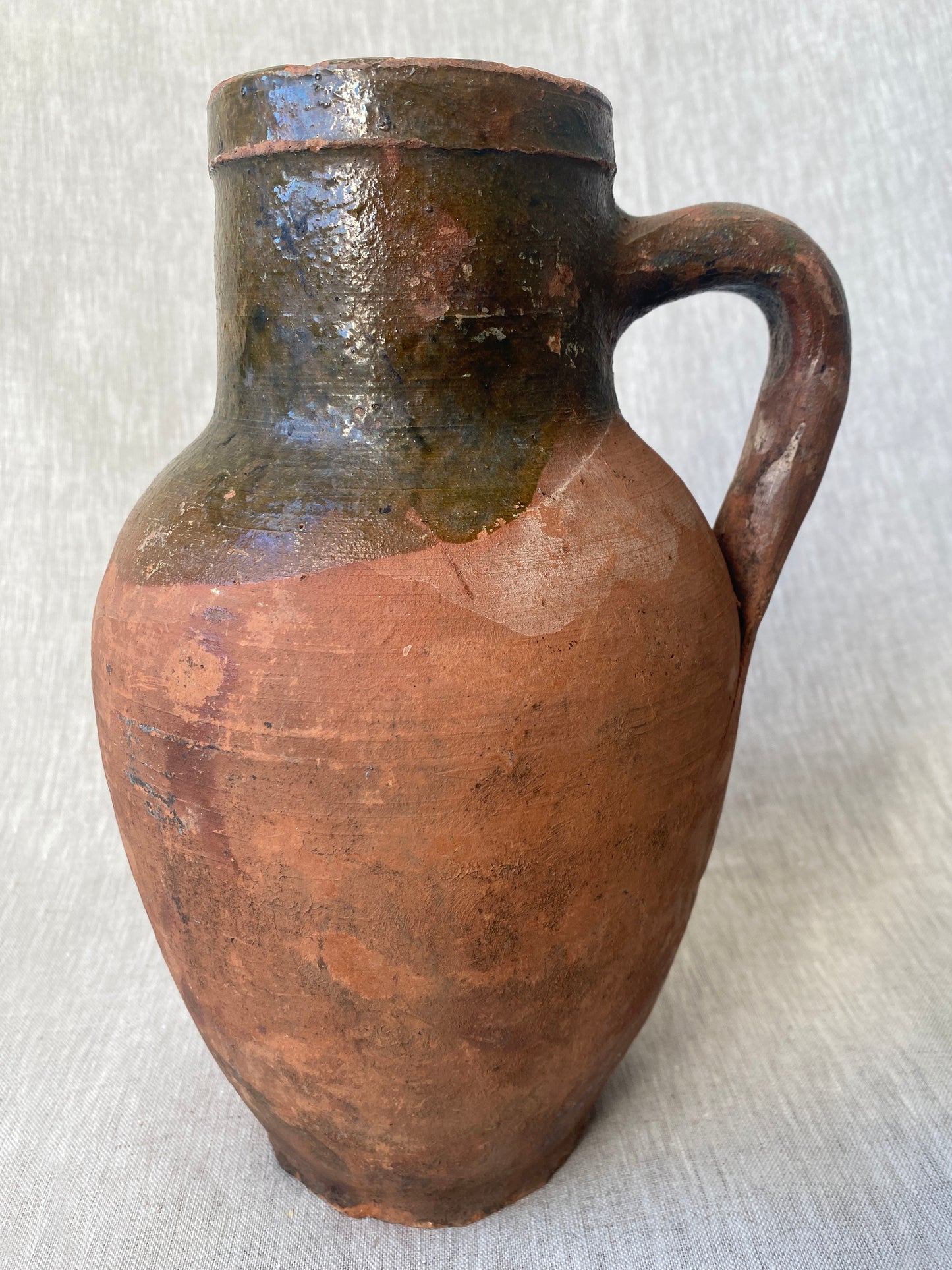 an antique turkish olive jar with a drip glaze