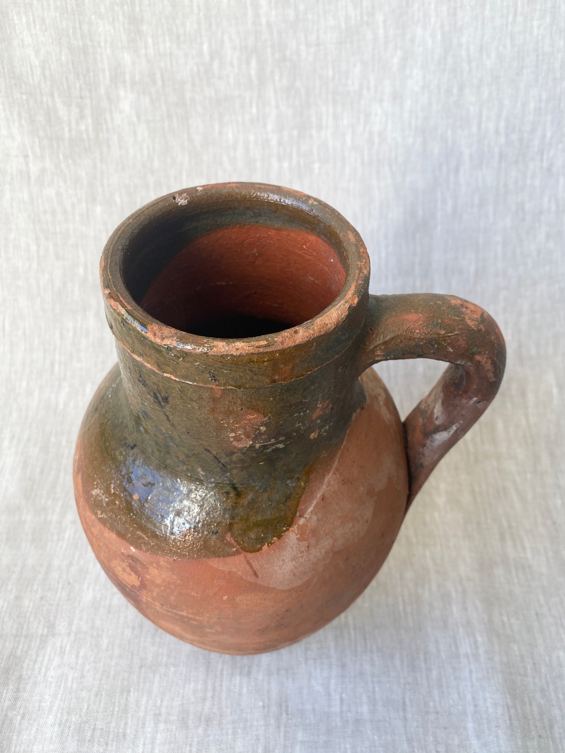 an antique turkish olive jar with a drip glaze