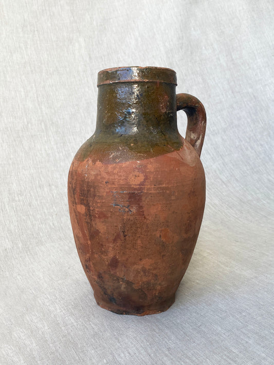 an antique turkish olive jar with a drip glaze